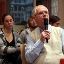 Ein Mann aus dem Publikum stallt an das Podium eine Frage